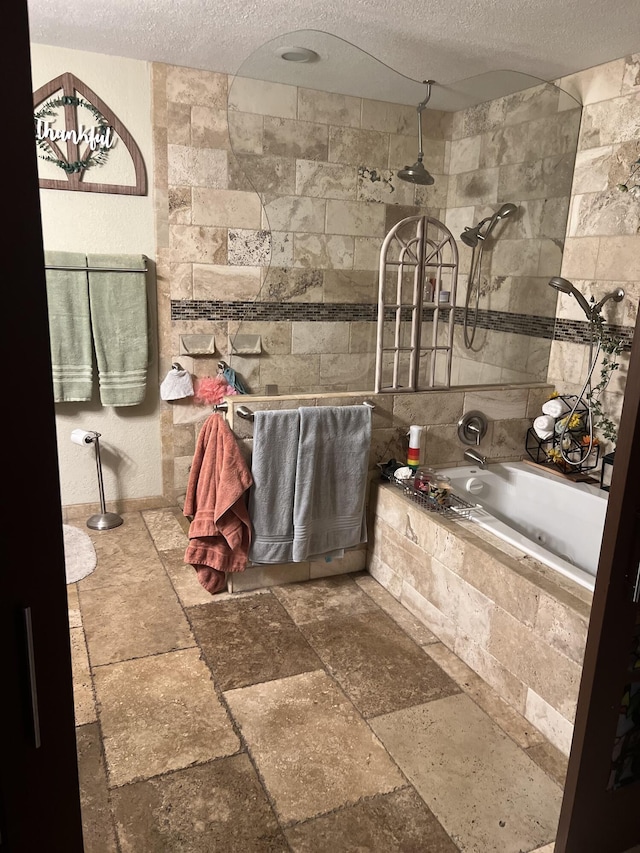 bathroom featuring a textured ceiling and shower with separate bathtub