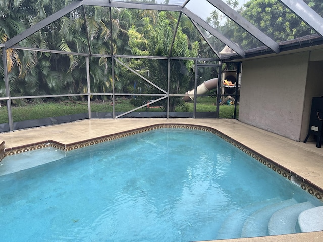 view of swimming pool with glass enclosure and a patio area