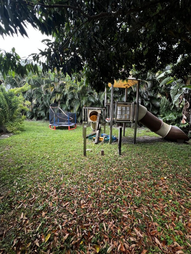 view of yard with a trampoline and a playground