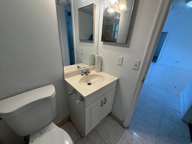 bathroom featuring vanity, toilet, and baseboards