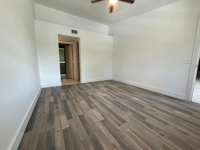 empty room with ceiling fan, wood finished floors, visible vents, and baseboards