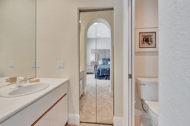 bathroom with toilet, vanity, and tile patterned floors