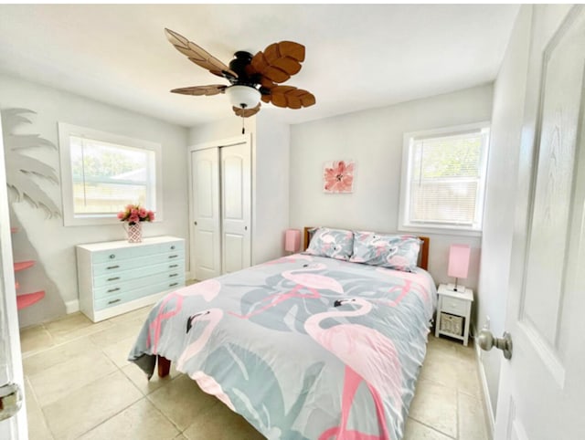 tiled bedroom with ceiling fan and a closet