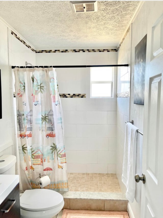 bathroom featuring a textured ceiling, toilet, vanity, and walk in shower