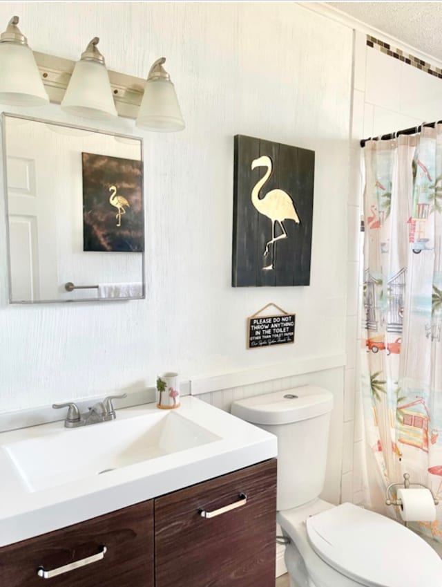 bathroom with curtained shower, vanity, and toilet