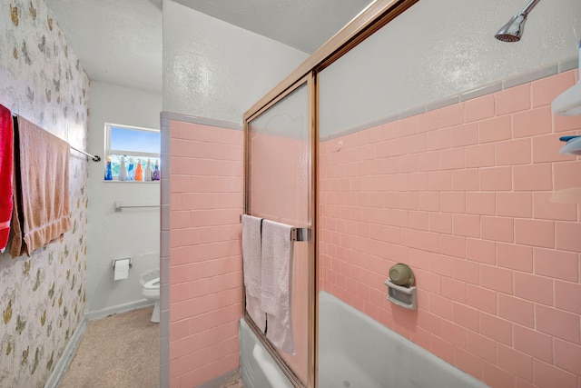 bathroom with combined bath / shower with glass door, toilet, and a textured ceiling