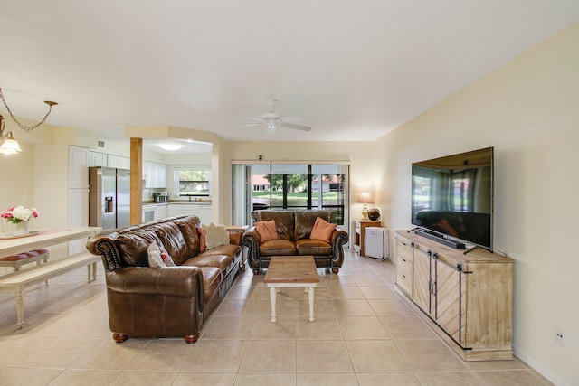 tiled living room with ceiling fan and sink