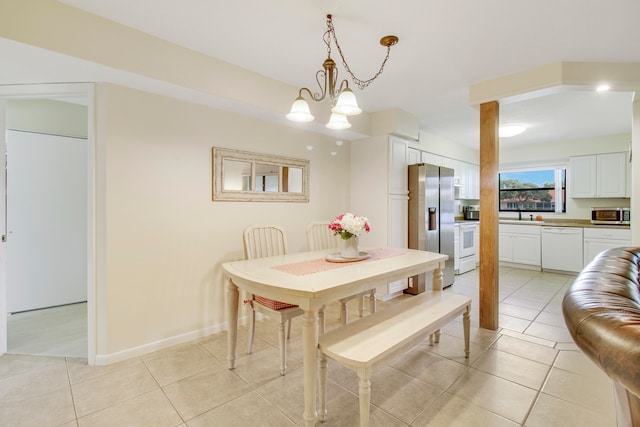 dining space with light tile patterned floors, sink, and an inviting chandelier