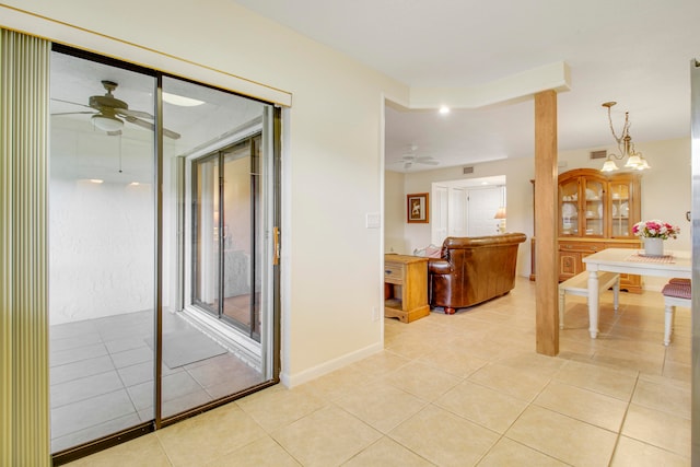 hallway featuring light tile patterned floors and an inviting chandelier