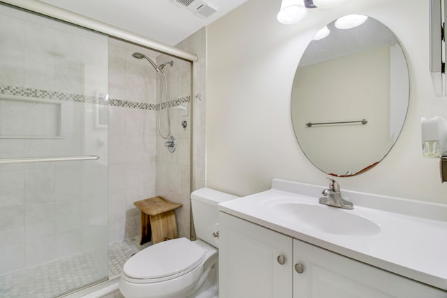 bathroom with a shower with door, vanity, and toilet