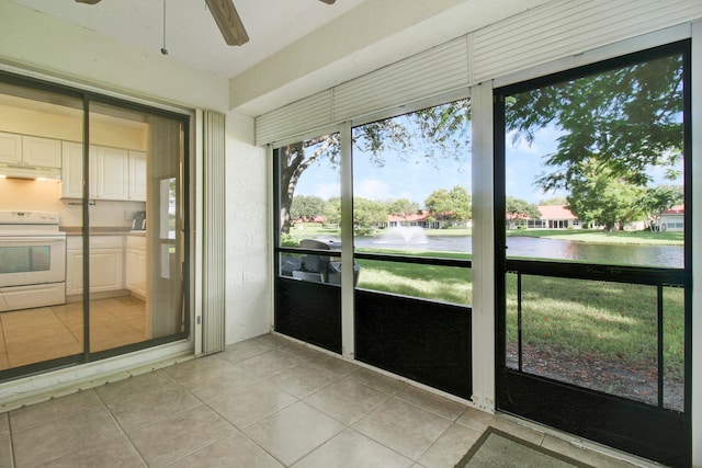 unfurnished sunroom featuring a water view and ceiling fan