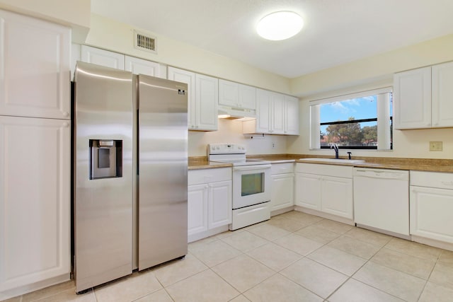 kitchen featuring white cabinets, white appliances, sink, and light tile patterned floors