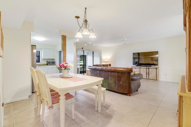 tiled dining area with ceiling fan with notable chandelier