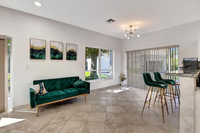 living area with an inviting chandelier, visible vents, a wealth of natural light, and recessed lighting