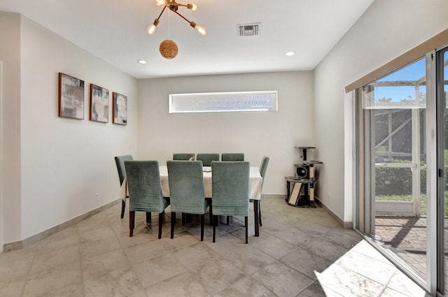 tiled dining area featuring a healthy amount of sunlight and a chandelier