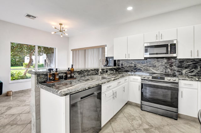 kitchen featuring white cabinetry, appliances with stainless steel finishes, and kitchen peninsula