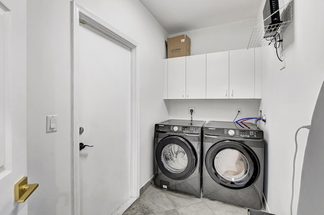 laundry area featuring independent washer and dryer, cabinet space, and baseboards