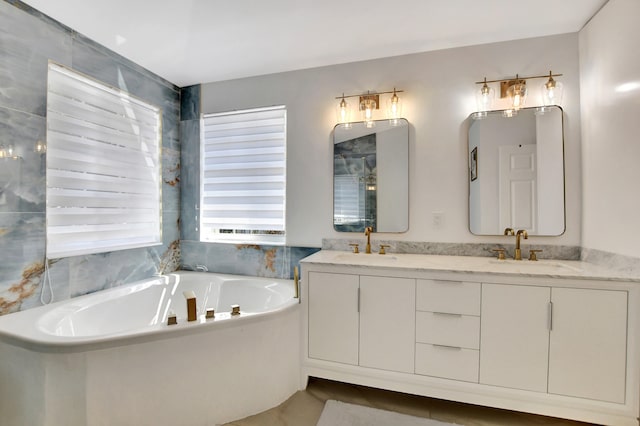 bathroom with tile patterned flooring, a tub, and vanity