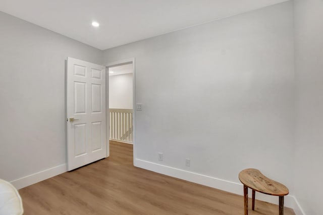 spare room featuring recessed lighting, light wood-style flooring, and baseboards