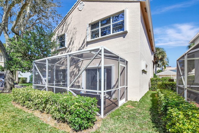 rear view of property featuring glass enclosure