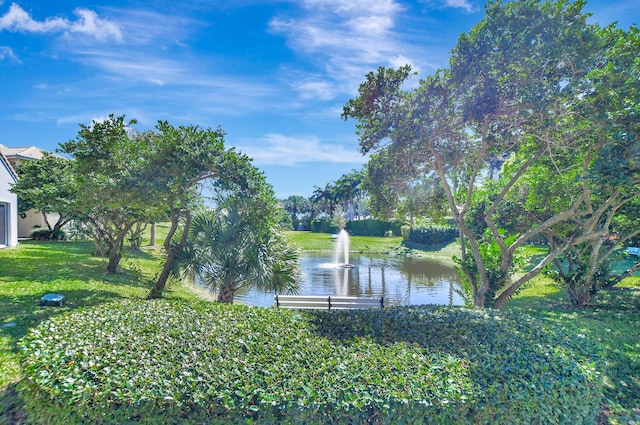 view of dock with a lawn and a water view