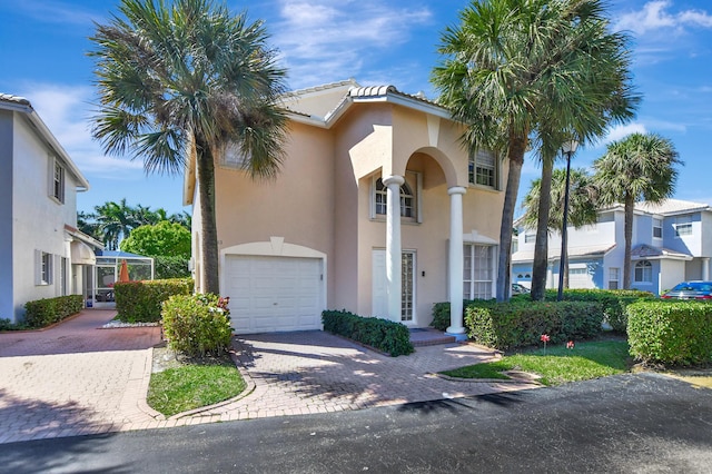 view of front of house with a garage, decorative driveway, and stucco siding