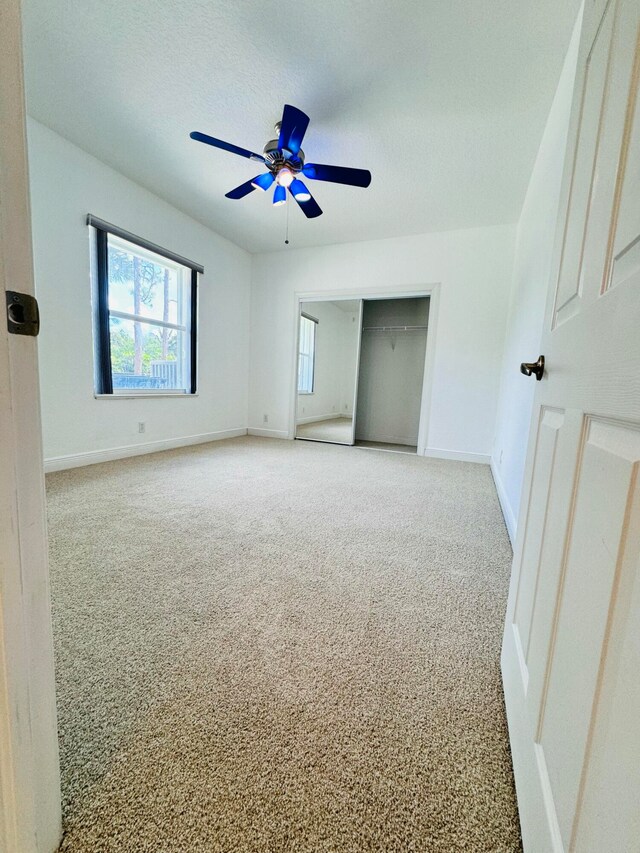 spare room featuring light carpet and ceiling fan