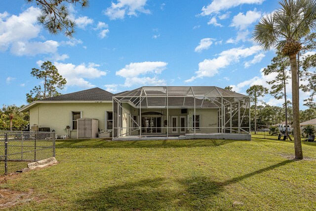 back of house featuring glass enclosure, a patio, and a yard