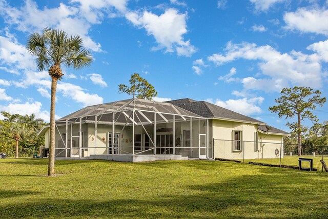 back of house with a patio, glass enclosure, and a lawn