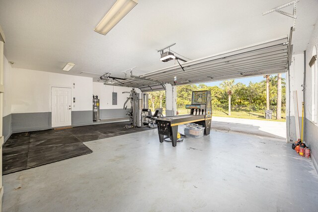 garage featuring electric panel and water heater