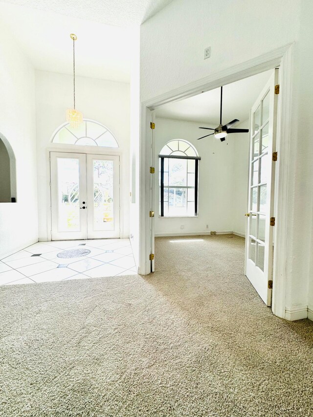 entryway with ceiling fan, a textured ceiling, light carpet, and french doors