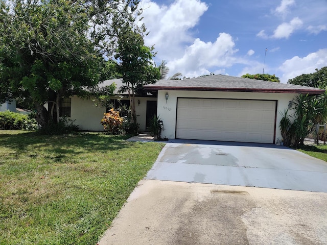 single story home with a garage and a front lawn