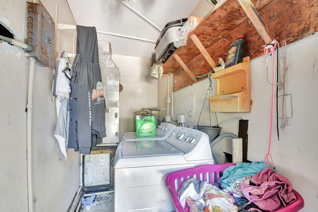 washroom with water heater and washer and clothes dryer