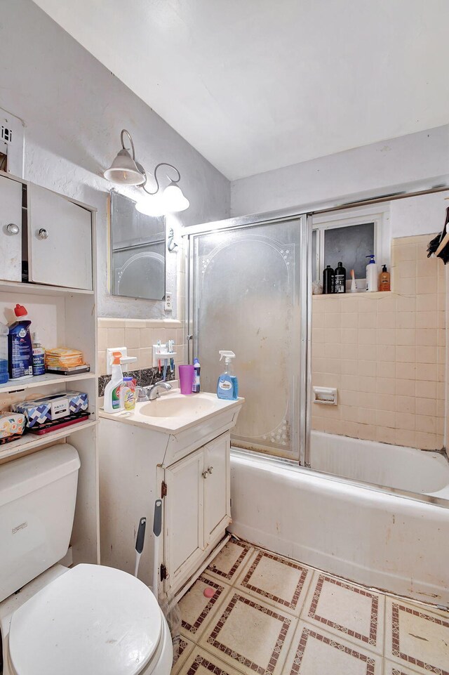 full bathroom with enclosed tub / shower combo, toilet, vanity, and tile patterned floors