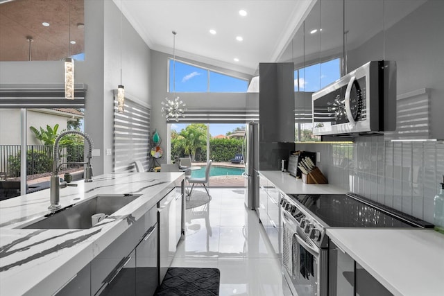 kitchen with light tile patterned floors, appliances with stainless steel finishes, tasteful backsplash, sink, and a healthy amount of sunlight