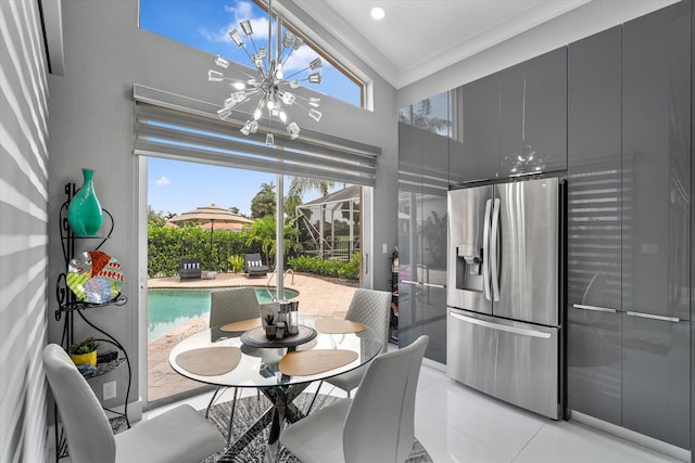 kitchen with stainless steel refrigerator with ice dispenser, a towering ceiling, and a chandelier