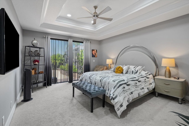 carpeted bedroom featuring a tray ceiling, access to outside, and ceiling fan