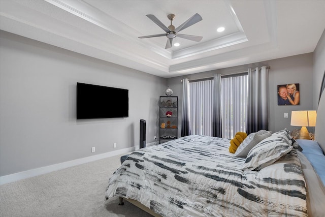 bedroom with carpet flooring, a tray ceiling, and ceiling fan