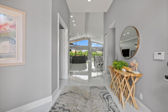 hall with vaulted ceiling and tile patterned floors