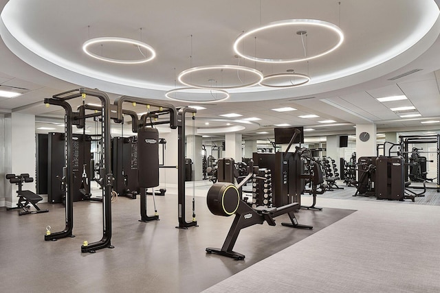 gym with a tray ceiling and a paneled ceiling