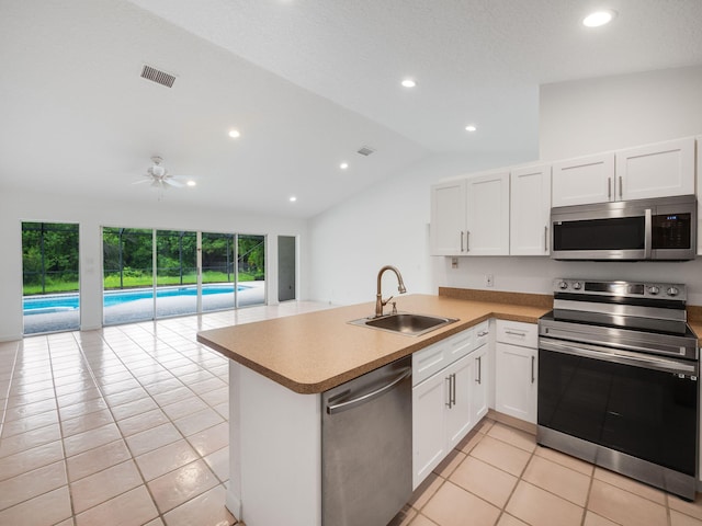 kitchen with visible vents, appliances with stainless steel finishes, white cabinetry, a sink, and a peninsula