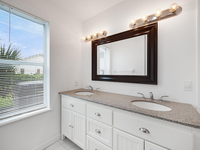 full bathroom with tile patterned flooring, a sink, baseboards, and double vanity