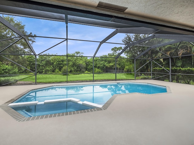 view of swimming pool featuring a pool with connected hot tub, glass enclosure, and a patio