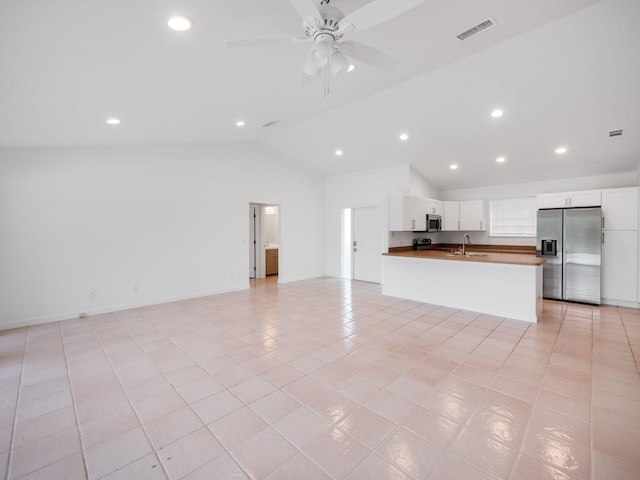 unfurnished living room featuring visible vents, lofted ceiling, ceiling fan, a sink, and light tile patterned flooring