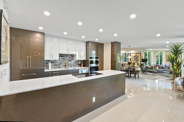 kitchen with stainless steel double oven, backsplash, sink, black electric cooktop, and white cabinets