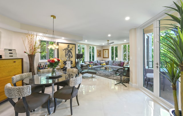 dining space with ceiling fan with notable chandelier and tile patterned floors