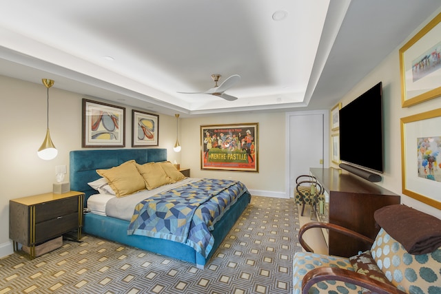 bedroom featuring a tray ceiling, ceiling fan, and carpet