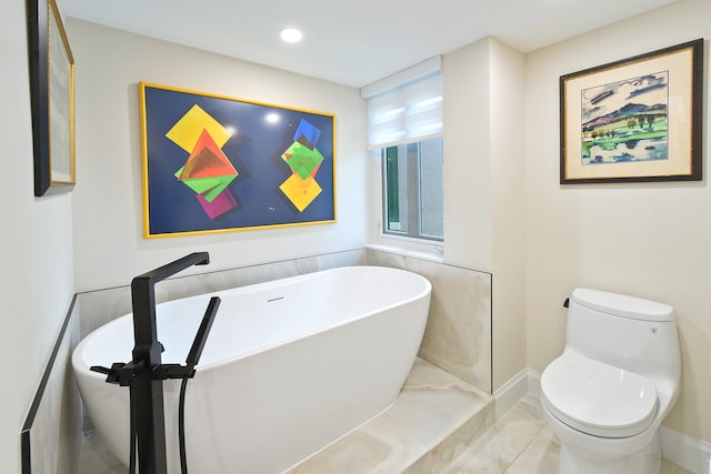 bathroom featuring toilet and a washtub