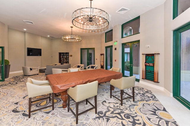 dining room featuring a towering ceiling, french doors, and a chandelier