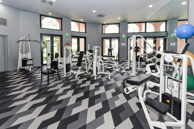 workout area with a towering ceiling and french doors